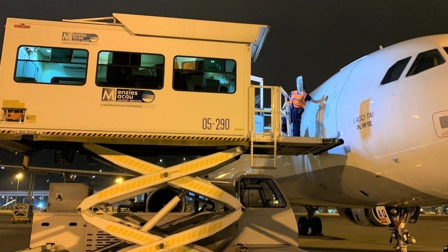 Menzies Macau team loading cargo into passenger cabin