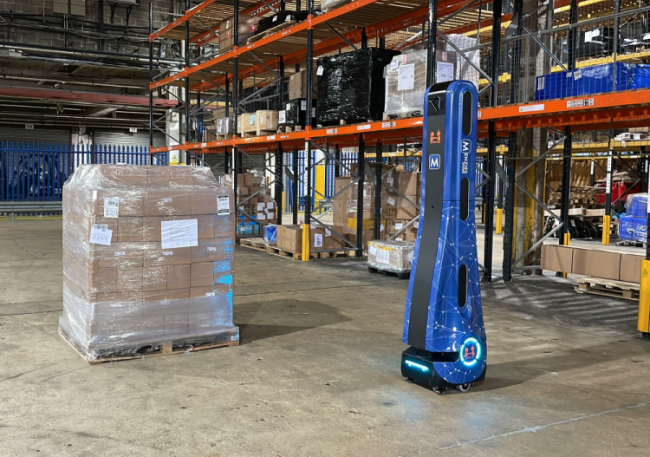A pallet in a warehouse next to a blue robot