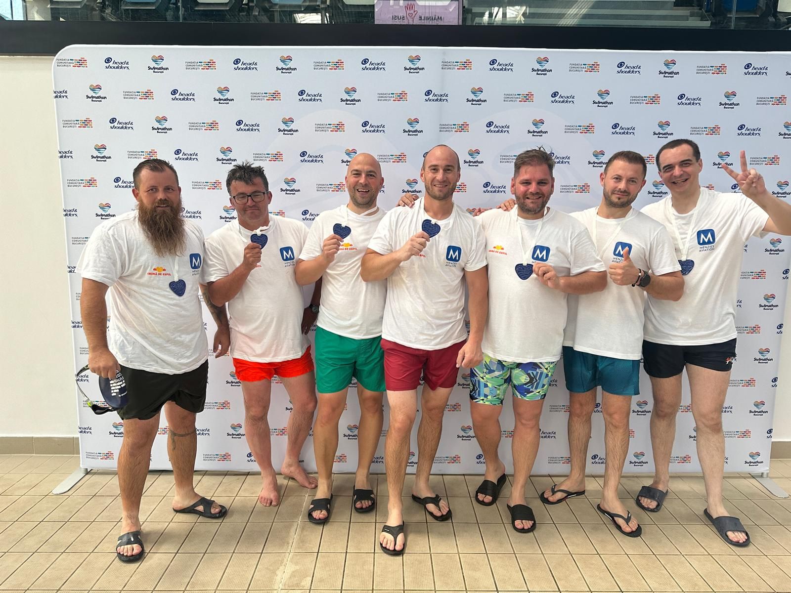 A group of Menzies employees standing together in Menzies t-shirts and shorts 