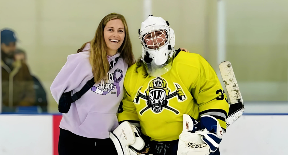 Sharon (left) smiles next to one of the players