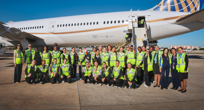 The students join Menzies and United colleagues for a photo in front of a large United Airlines Boeing 787 Dreamliner parked on the stand.